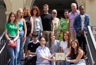 Sozialreferentin Dr. Hülya Düber (li. vorne sitzend) nimmt die Spende der Schülerinnen und Schüler der Gustav-Walle-Schule über 700 Euro für geflüchtete Kinder entgegen. Schulleiter Matthias Schranner (hinten, 2.v.re.) und einige Lehrerinnen und Lehrer begleiteten die Schülerinnen und Schüler zum Termin ins Rathaus.