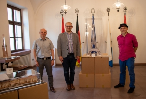 (von links nach rechts) Daniel Stein (Vorstand Schloss- und Gartenverwaltung Würzburg), Alexander Kolbow (SPD-Fraktionsvorsitzender) und Gerd Paul umgeben von den Kartonmodellen „Schloss Schönbrunn“, „Giralda Sevilla“ und „Eiffelturm“.
