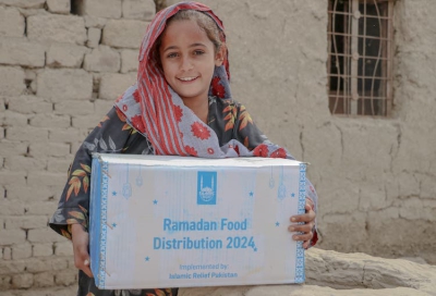 Ein Mädchen im Grenzgebiet zwischen Afghanistan und Pakistan freut sich über ihr Lebensmittelpaket. Beide Länder waren zuletzt von Klimaextremen wie Dürre und Überschwemmungen betroffen.  Foto: Islamic Relief