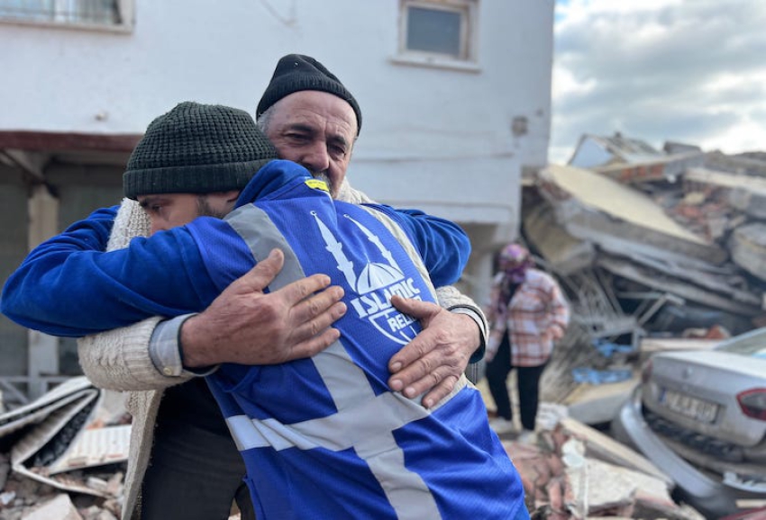 Bildunterschrift: Ein Helfer von Islamic Relief umarmt einen Mann in der Türkei, dessen Haus bei den Erdbeben vor einem Jahr zerstört wurde (Copyright Islamic Relief).