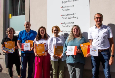 Die bilingualen Arbeitshefte werden zu Beginn des neuen Schuljahres an die ukrainischen Grundschülerinnen und Grundschüler verteilt. Erstellt wurden sie von Maren Gronert (2.v.re.), Alla Robeyko (3.v.re.) und Larissa Hartmann (3.v.li.). Finanziert wurde das Lernpaket aus dem Spendentopf der Stadt Würzburg für Angebote für Kinder, Jugendliche und Familien aus der Ukraine. Ingo Matschullis (2.v.li.) vom staatlichen Schulamt, Gunther Kunze (re., Leiter des Fachbereichs Jugend und Familie Stadt Würzburg) und Monika Kraft (li., stv. Leiterin des Fachbereichs Jugend und Familie) freuen sich über die didaktisch gut aufgebauten Lehrmittel.  Foto: Claudia Lother